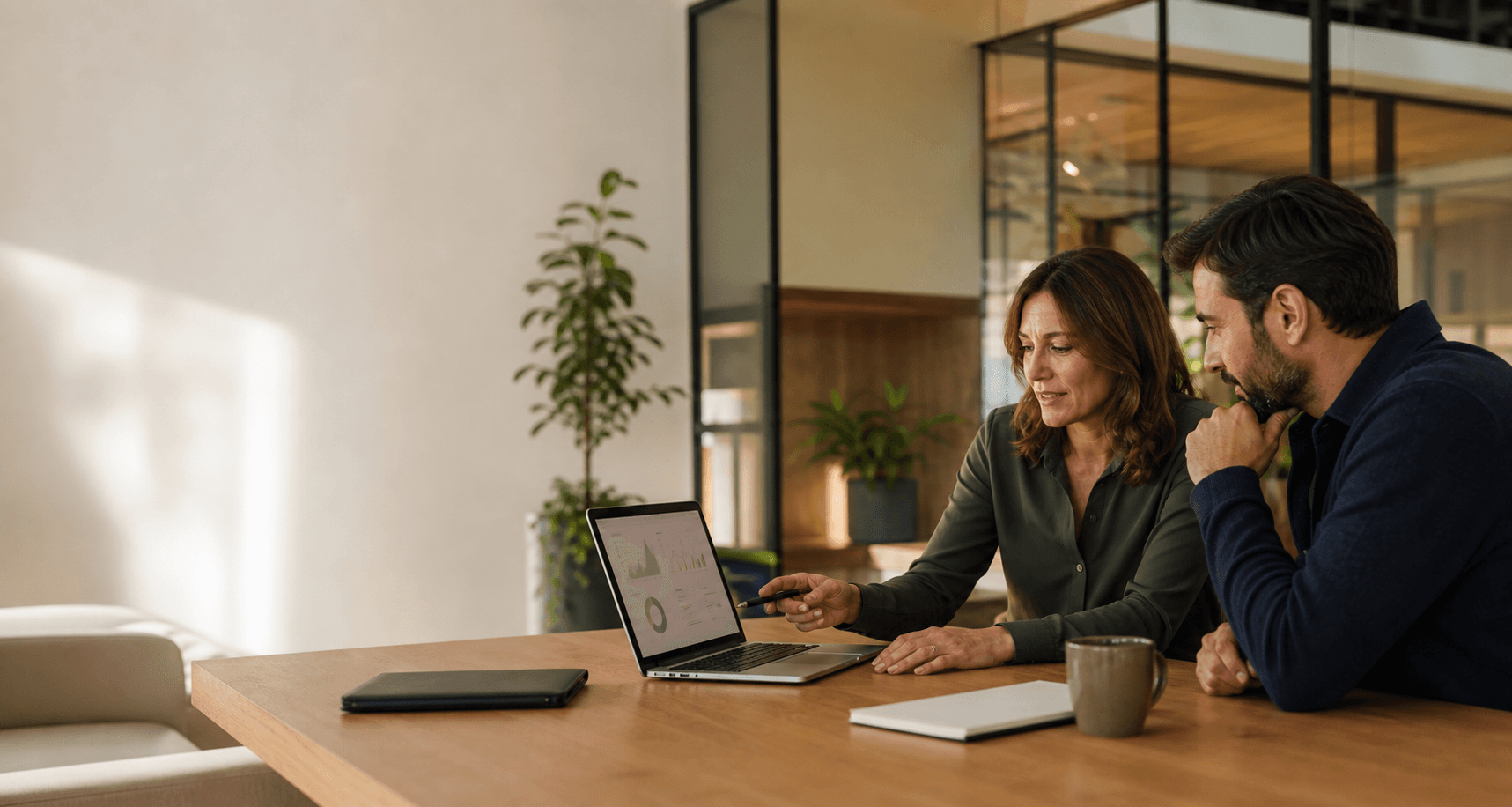 Executive coach reviewing a leadership progress dashboard with a client in a modern office
